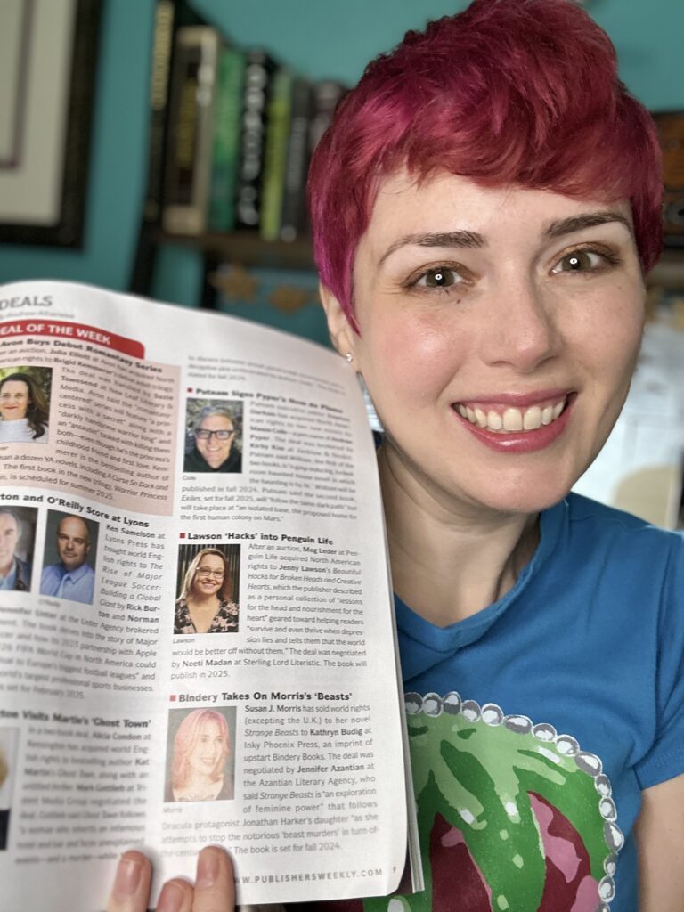 picture of Susan smiling holding Publishers Weekly open to the Deals page, where her book STRANGE BEASTS and her photo are in the magazine with a short description that reads as follows: Susan J. Morris has sold world rights (excepting the U.K.) to her novel Strange Beasts to Kathryn Budig at Inky Phoenix Press, an imprint of upstart Bindery Books. The deal was negotiated by Jennifer Azantian at the Azantian Literary Agency, who said Strange Beasts is an "exploration of feminine power" that follows Dracula protagonist Jonathan Harker's daughter "as she attempts to stop the notorious 'beast murders' in turn-of-the-century Paris." The book is set for Fall 2024."